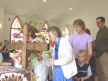 Florence Hughes adds flowers to the cross