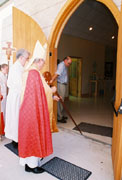 the Bishop marks the sign of the cross on the threshold